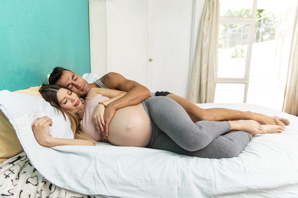 Kobieta w ciąży i mężczyzna w łóżku, a seks